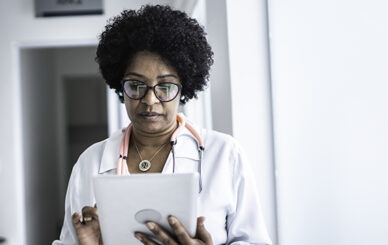 Mature female doctor using digital tablet at medical office